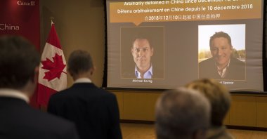 A video screen displays images of Canadians Michael Kovrig,(L), and Michael Spavor at an event held in connection with the announcement of the sentence for Spavor at the Canadian Embassy in Beijing, China, Aug. 11, 2021. (AP Photo)