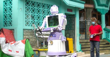 Aseyanto, 53, a resident of the Tembok Gede neighborhood, operates the "Delta Robot", made from household items like pots, pans and an old television monitor, in Surabaya, East Java province, Indonesia, Aug. 7, 2021. (Reuters Photo)