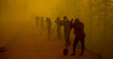 Volunteers pause while working at the scene of forest fire near Kyuyorelyakh village at Gorny Ulus area west of Yakutsk, Russia, Aug. 7, 2021. (AP Photo)