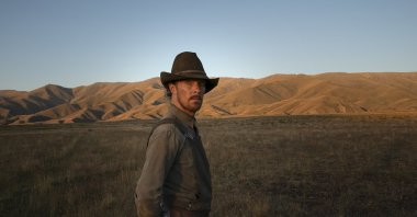 Benedict Cumberbatch as Philip Burbank, looks off camera in a scene from the film “The Power of the Dog.” (Netflix via AP)