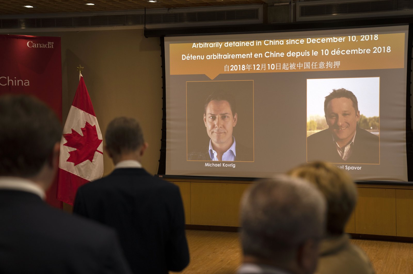 A video screen displays images of Canadians Michael Kovrig,(L), and Michael Spavor at an event held in connection with the announcement of the sentence for Spavor at the Canadian Embassy in Beijing, China, Aug. 11, 2021. (AP Photo)