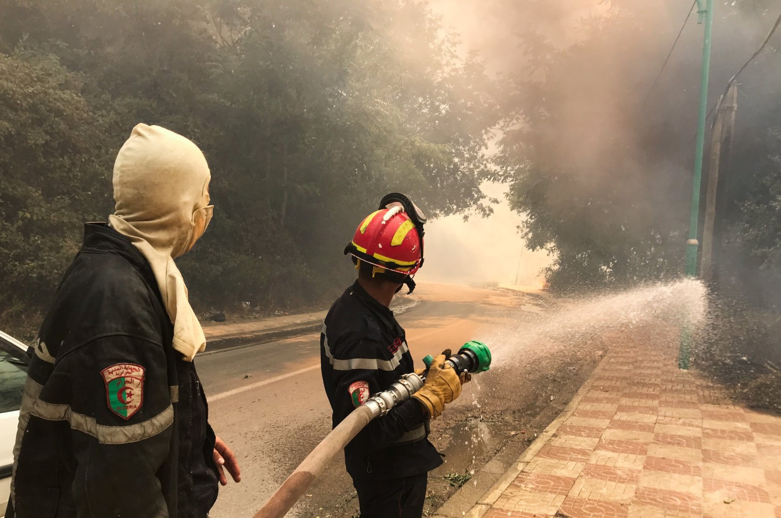 A firefighter uses a water hose during a forest fire in Ain al-Hammam village in the Tizi Ouzou region, east of Algiers, Algeria, Aug. 10, 2021. (Reuters Photo)