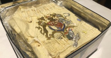 The tin containing the plastic-wrapped slice of cake from one of the 23 official wedding cakes made for the Royal Wedding of Prince Charles and Lady Diana Spencer, Dominic Winter Auctioneers in Cirencester, England, Aug. 11, 2021. (Claire Hayhurst/PA via AP)