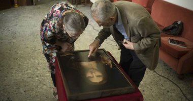 Dianne Modestini (L), and Ashok Roy inspect the Naples copy of the Salvator Mundi in a scene from the documentary "The Lost Leonardo." (Sony Pictures Classics via AP)