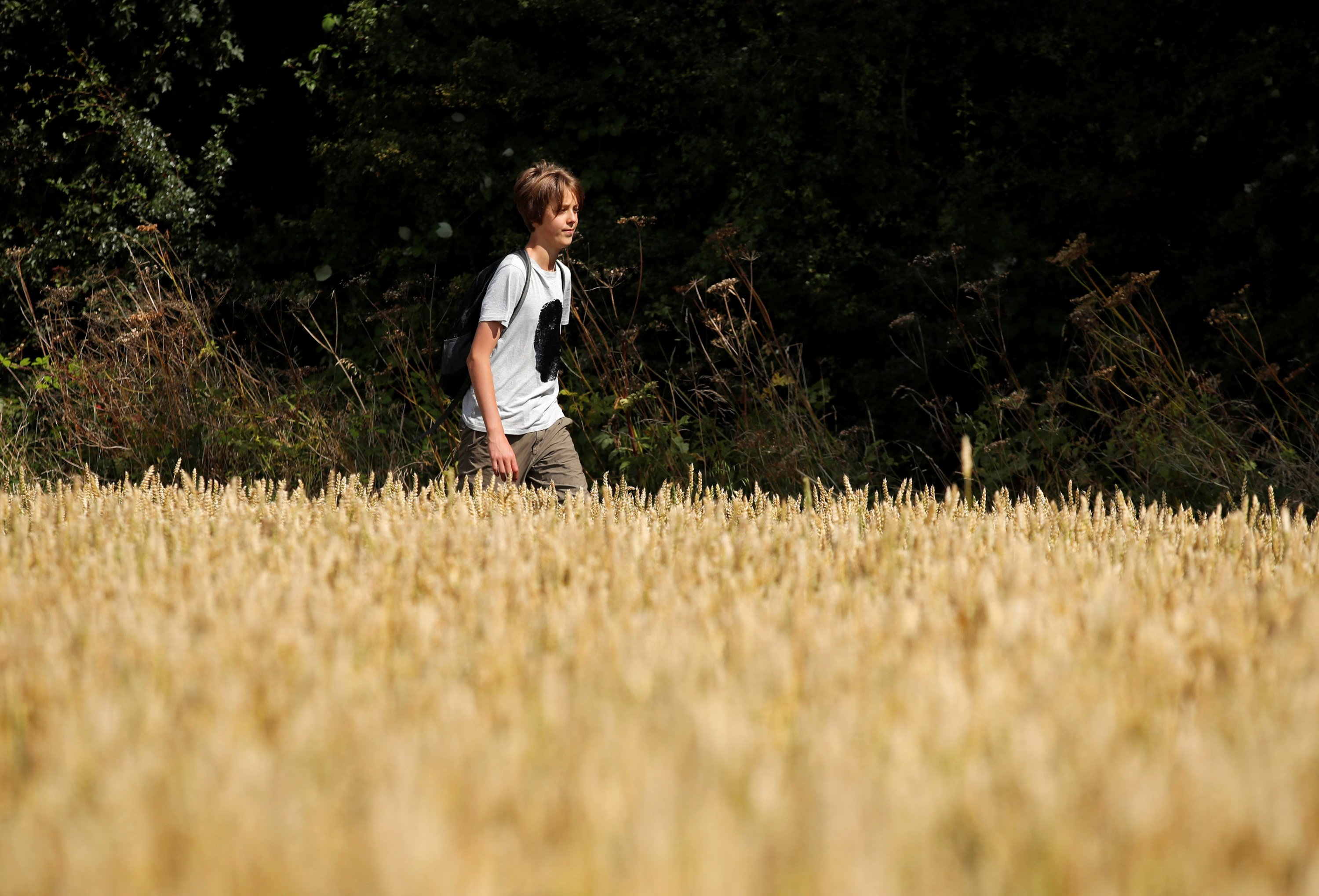 Jude Walker, 11, during his 210-mile (340-km) walk from Yorkshire to London over 21 days to raise awareness for "the zero carbon campaign" petition, which calls for the government to implement a carbon tax, in Milton Keynes, Britain, Aug. 10, 2021. (REUTERS/Andrew Couldridge)