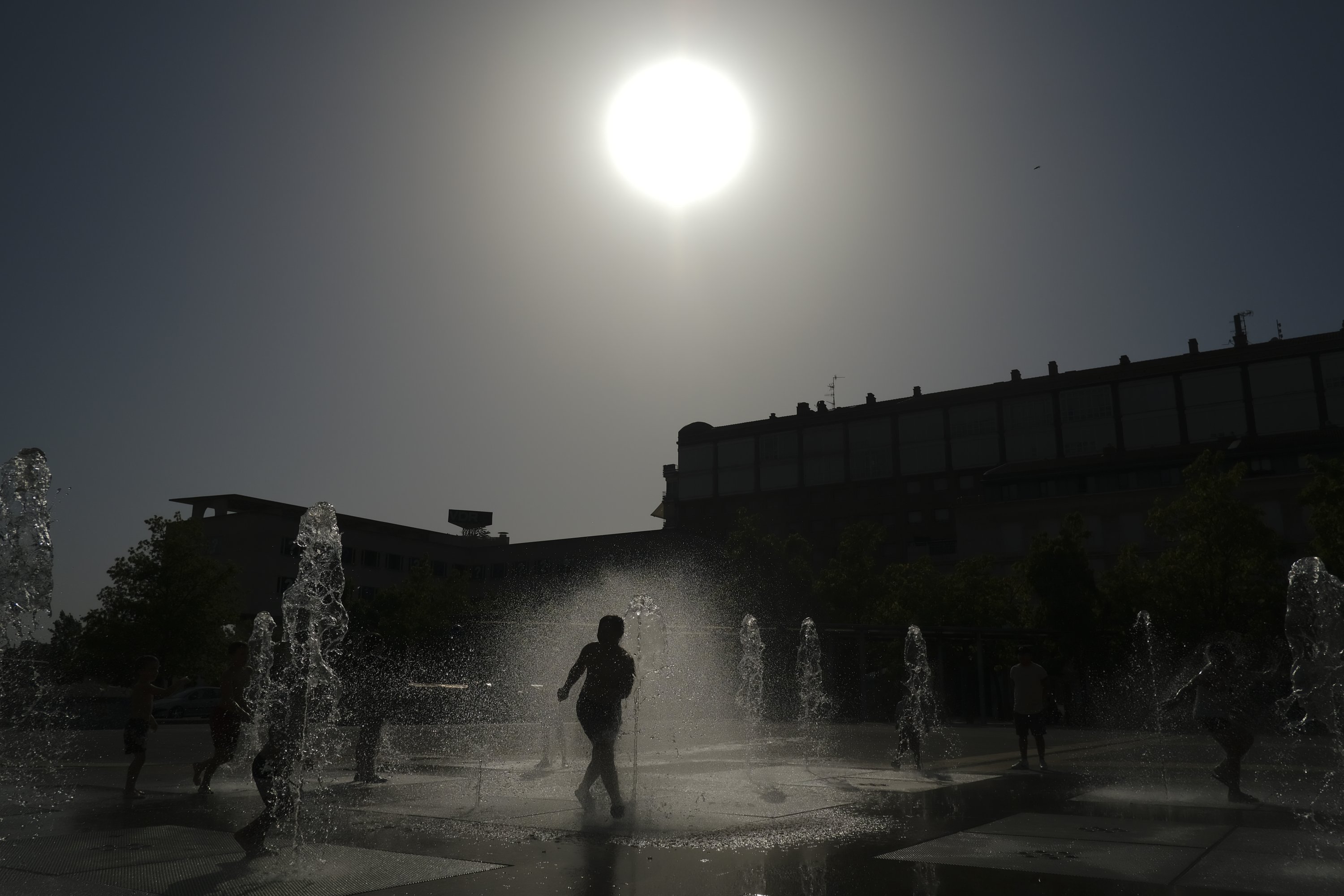 A child cools off with the water to the fountain during a heatwave in Pamplona, northern Spain, Aug. 13, 2021. (AP Photo)