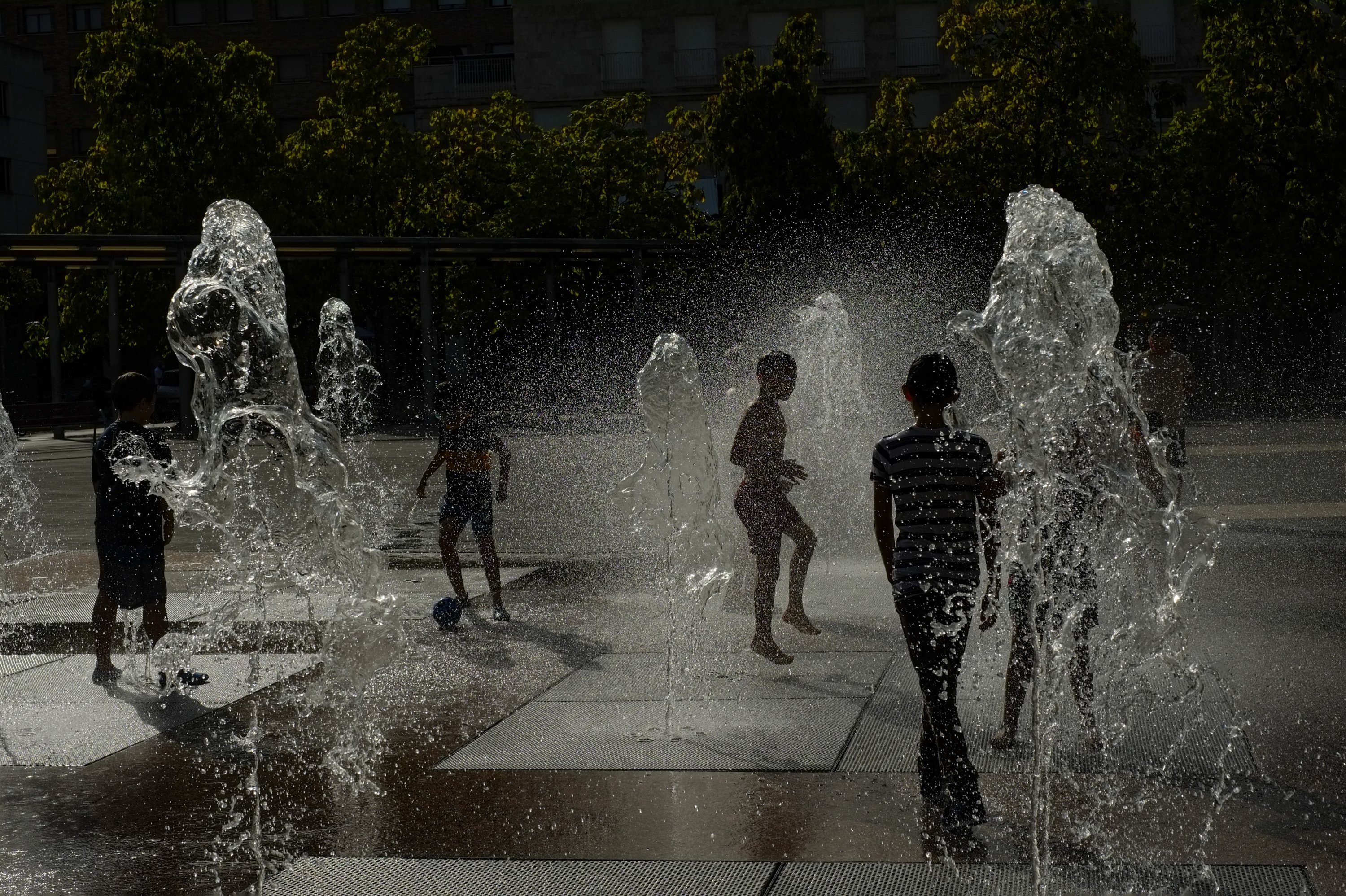 Children cool off with the water to the fountain during a heatwave in Pamplona, northern Spain, Aug. 13, 2021. (AP Photo)