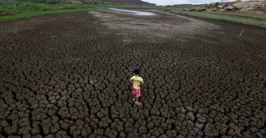 A boy stands on the cracked ground of the Boqueirao reservoir in the Metropolitan Region of Campina Grande, Paraiba state, Brazil, Feb. 13, 2017. (Reuters Photo)