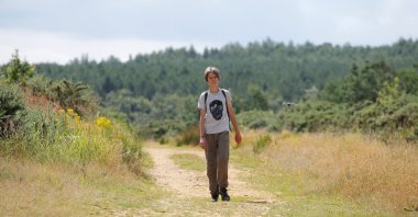 Jude Walker, 11, during his 210-mile (340-km) walk from Yorkshire to London over 21 days to raise awareness for "the zero carbon campaign" petition, which calls for the government to implement a carbon tax, in Milton Keynes, Britain, Aug. 10, 2021. (REUTERS/Andrew Couldridge)