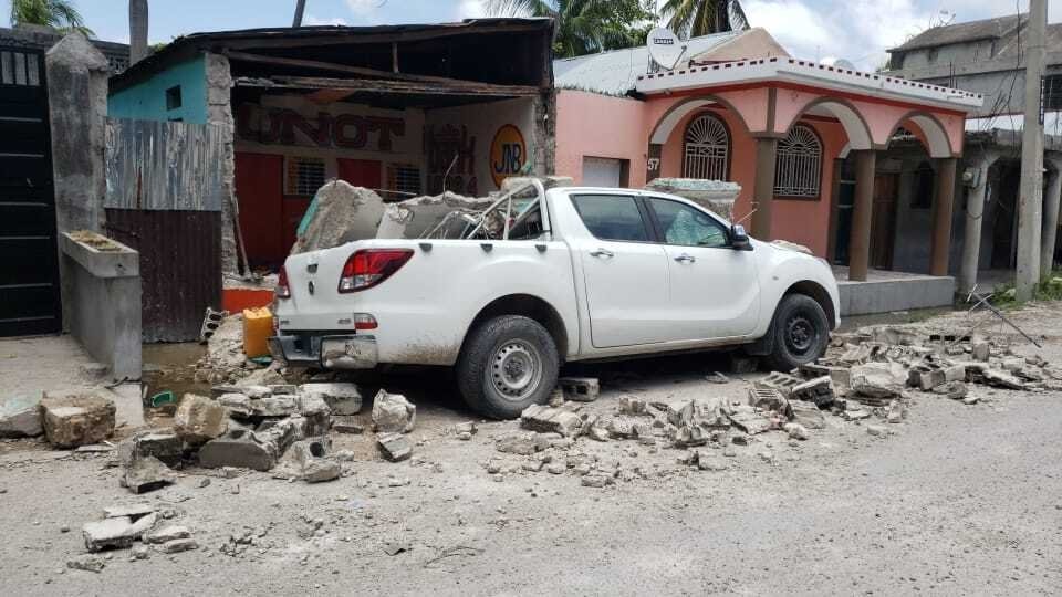 A truck is covered by parts of a wall that fell on it during an earthquake in Les Cayes, Haiti, Saturday, Aug. 14, 2021. (AP Photo)