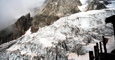 An alpinist stands on the balcony of the Boccalatte Hut on the Planpincieux Glacier in Courmayeur, Alps Region, north-western Italy, Aug. 5, 2021. (AFP Photo)