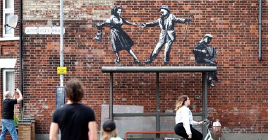 People stop to look at artwork created by Banksy in Great Yarmouth, U.K., Aug. 8, 2021. (Reuters Photo)