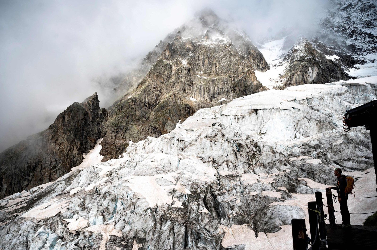 An alpinist stands on the balcony of the Boccalatte Hut on the Planpincieux Glacier in Courmayeur, Alps Region, north-western Italy, Aug. 5, 2021. (AFP Photo)