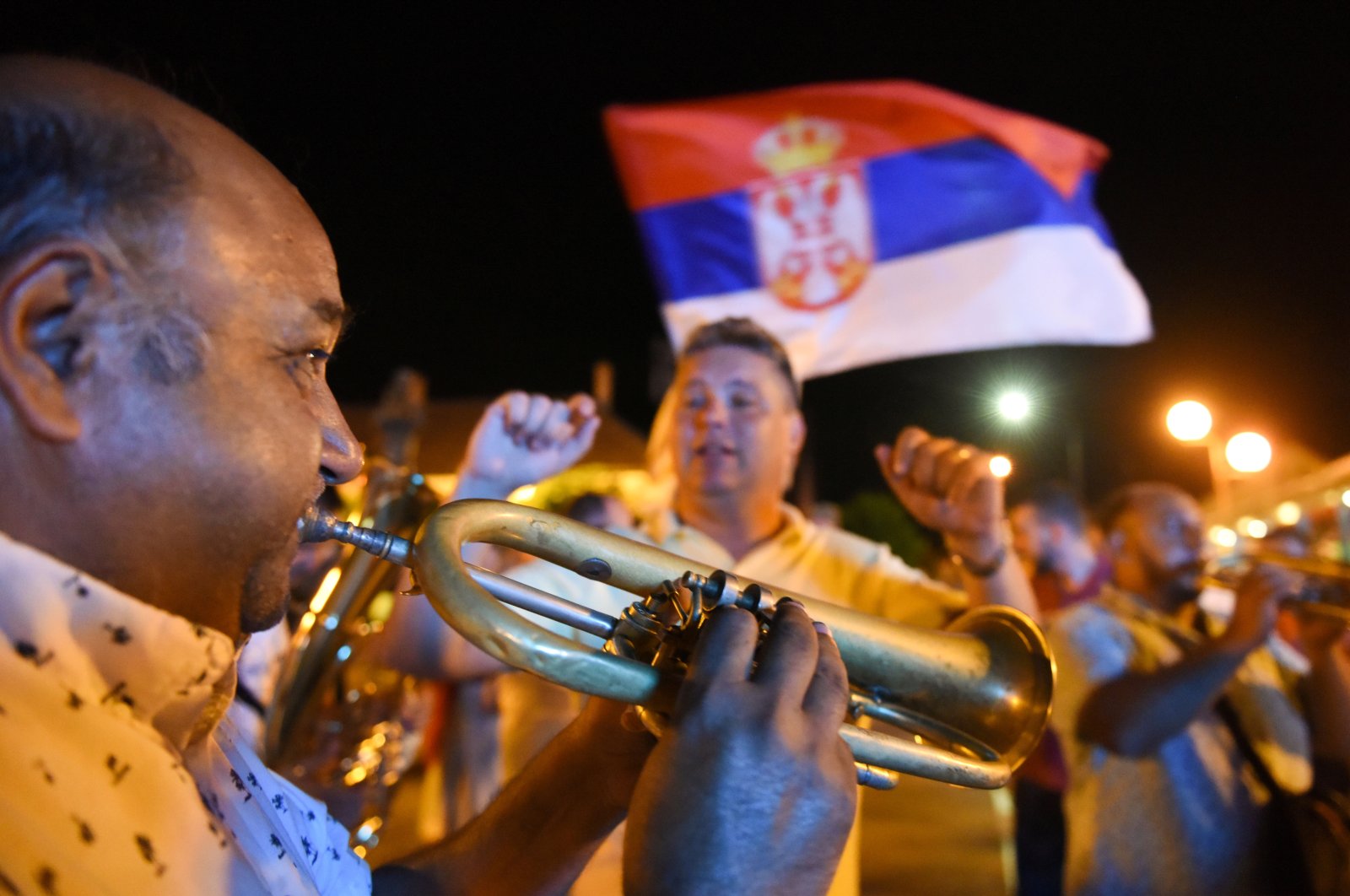People sing and dance on a street during the annual brass band festival, in Guca, Serbia, Aug. 13, 2021. (Reuters Photo)