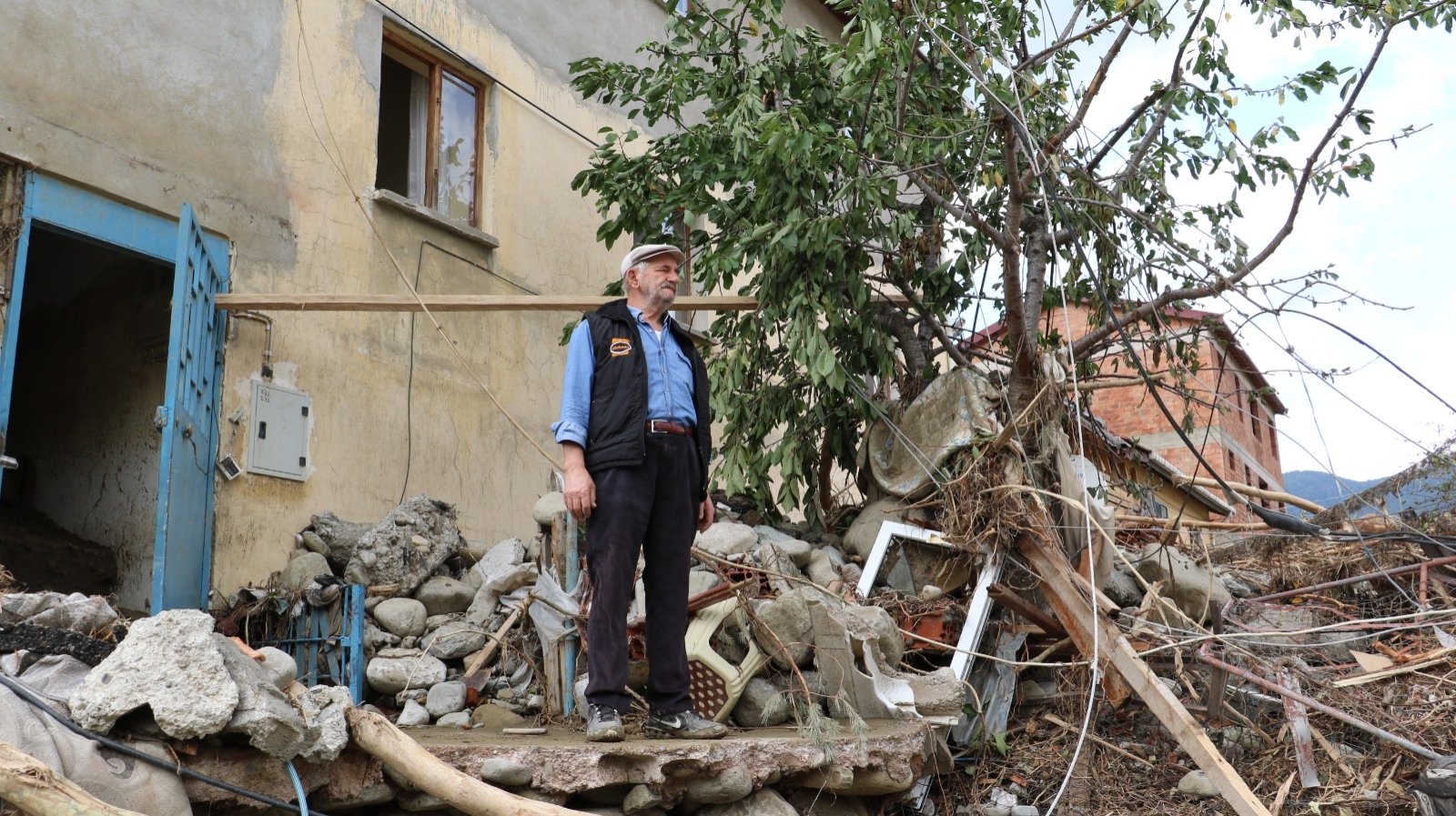A man stands among debris outside his home in Babaçay, in Sinop, northern Turkey, Aug. 15, 2021. (DHA PHOTO) 