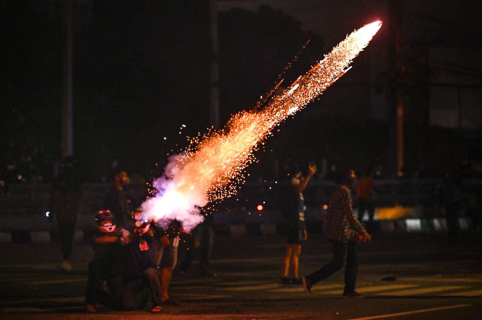 Protesters set off fireworks as they take part in a demonstration in Bangkok on Aug. 15, 2021, calling for the resignation of Thailand's Prime Minister Prayut Chan-Ocha over the government's handling of the COVID-19 crisis. (AFP Photo)