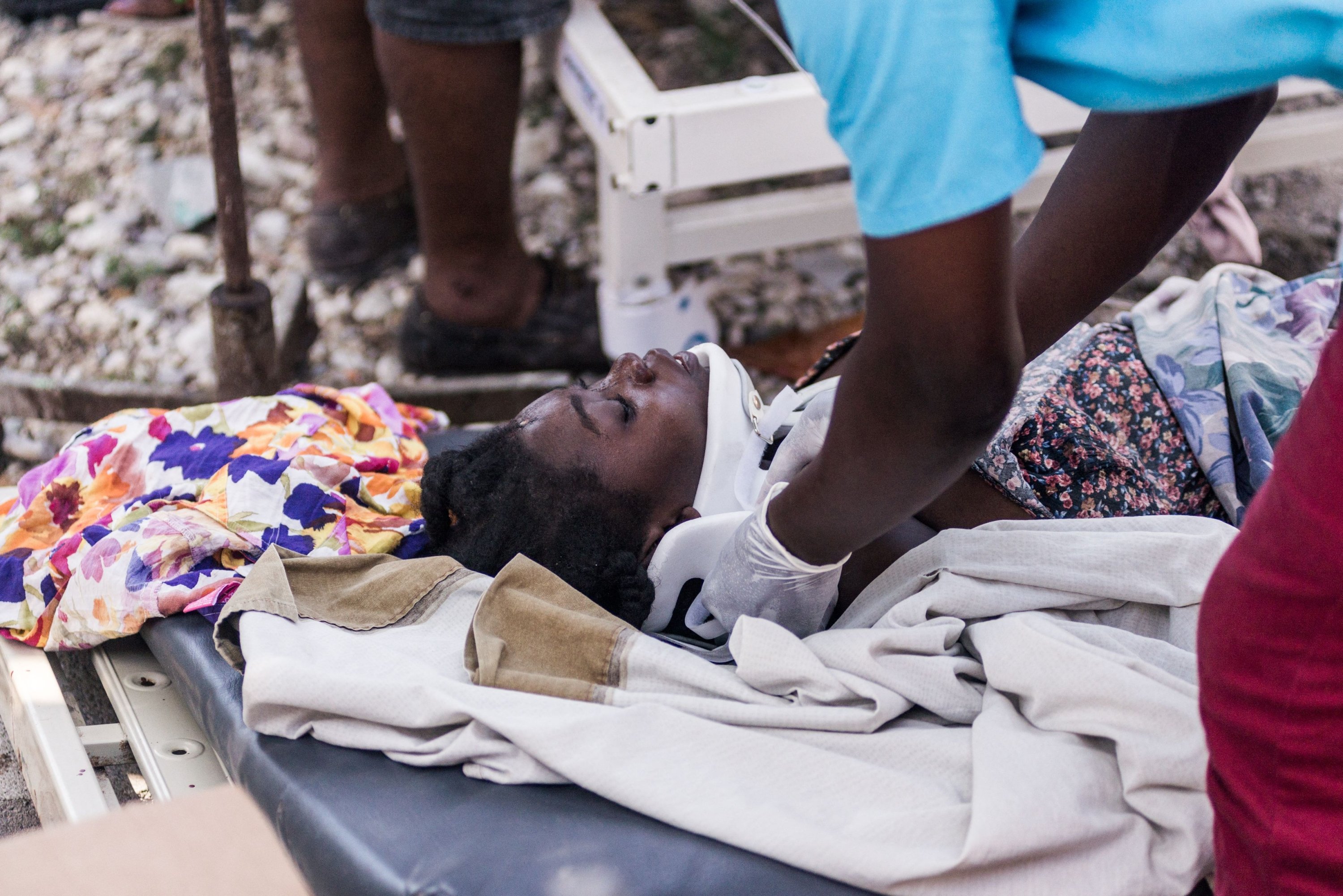 An injured woman has her neck braced by a doctor at a hospital in Les Cayes on Aug. 15, 2021, after a 7.2-magnitude earthquake struck the southwest peninsula of Haiti. (AFP Photo)