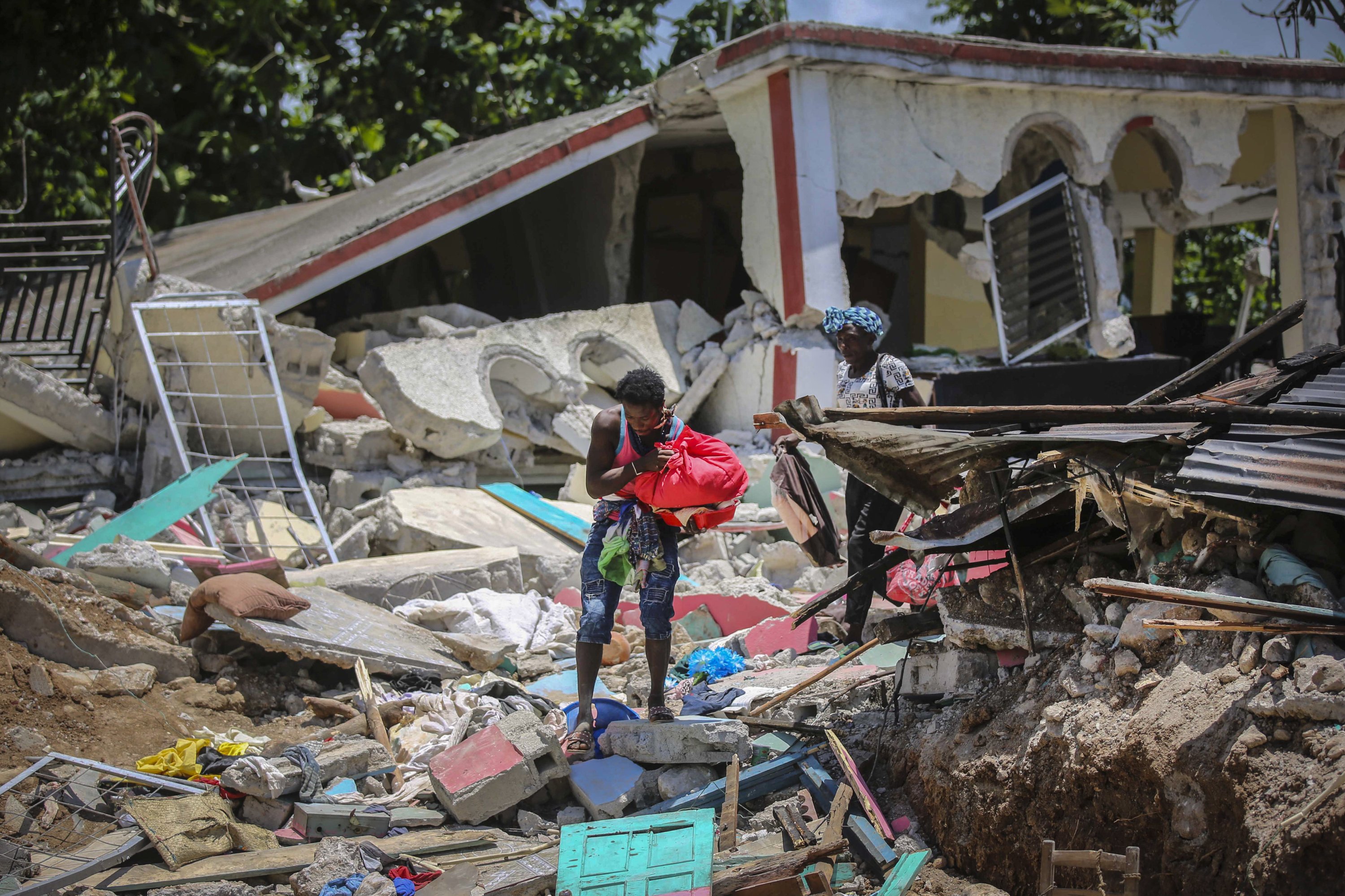 Locals recover their belongings from their homes destroyed in the earthquake in Camp-Perrin, Les Cayes, Haiti, Aug. 15, 2021. (AP Photo)