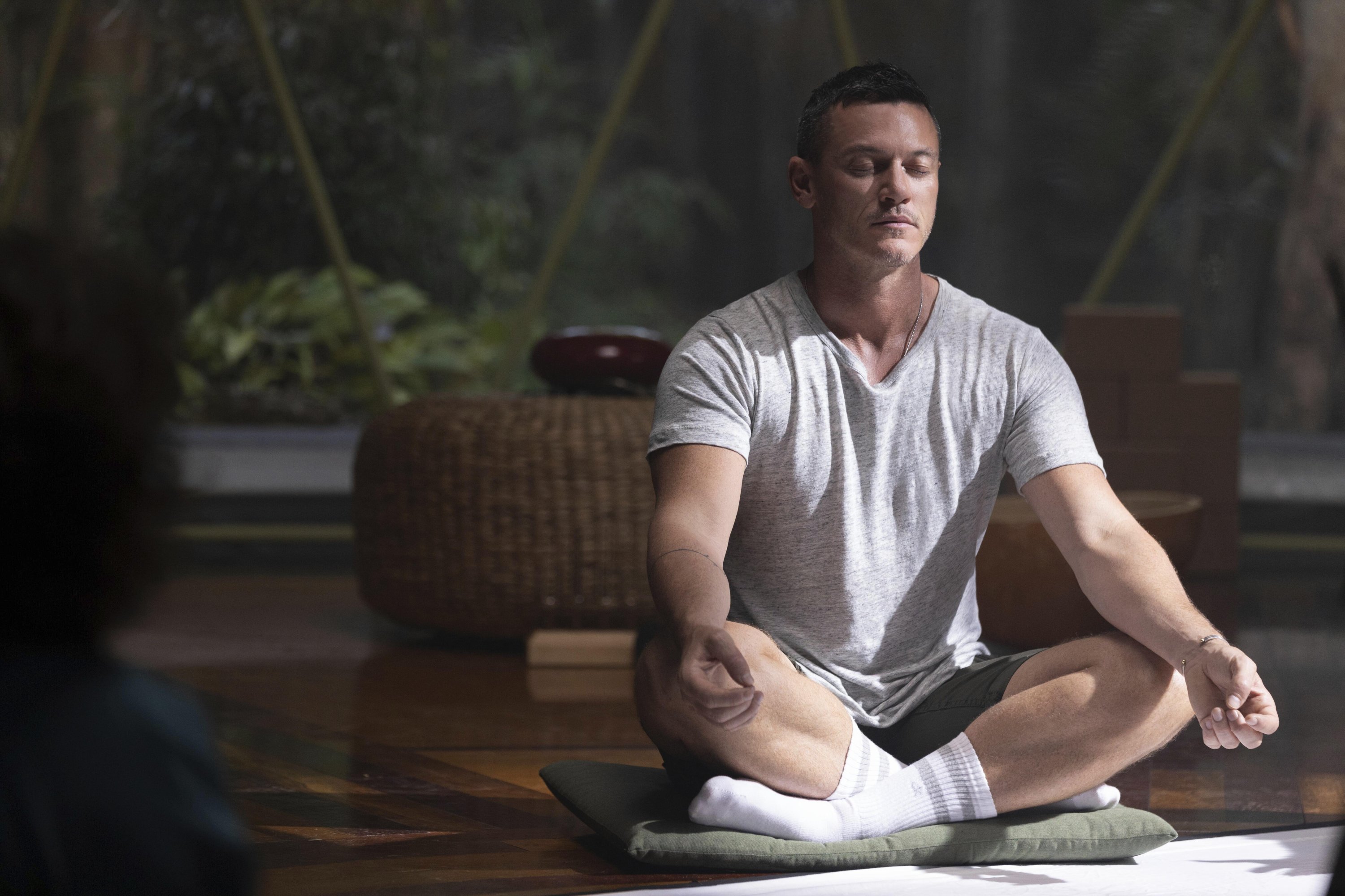 Luke Evans meditates in a scene from the series 'Nine Perfect Strangers,' premiering Aug. 18 on Hulu. (Hulu via AP)