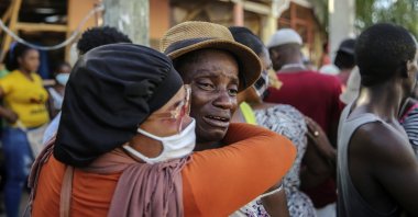 People cry during the search for those who are still missing in a house destroyed by the earthquake in Les Cayes, Haiti, Sunday, Aug. 15, 2021.  (AP Photo)