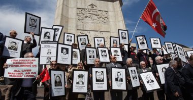 A retired diplomat holds a placard reading “All lives matters, as do Turks lives,” among others with portraits of victims of Armenian terrorist attacks in front of Atatürk Monument in Ulus Square, Ankara, Turkey, on April 4, 2015. (Getty Images Photo)