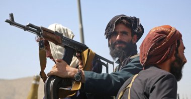 Taliban fighters stand guard in a vehicle along the roadside after a stunningly swift end to Afghanistan's 20-year war, as thousands of people mobbed the city's airport trying to flee the group's feared hardline brand of rule, Kabul, Afghanistan, Aug. 16, 2021. (AFP Photo)