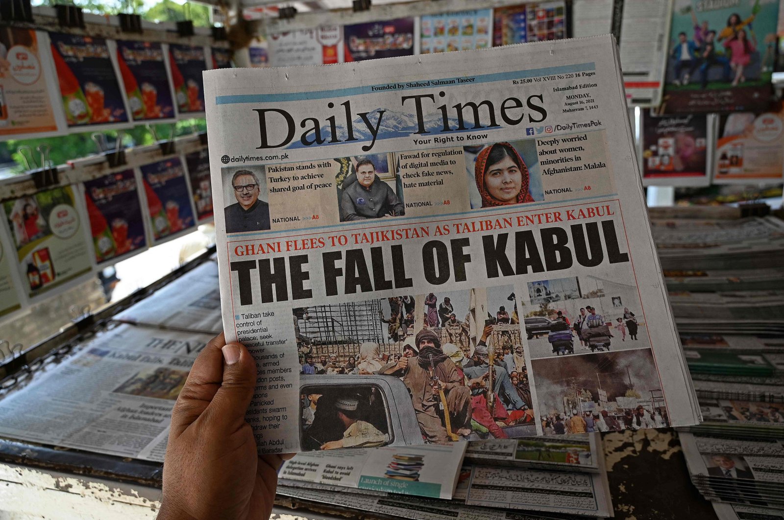 A man holds a newspaper displaying front page news about Afghanistan, at a stall in Islamabad, Pakistan, Aug. 16, 2021. (AFP Photo)