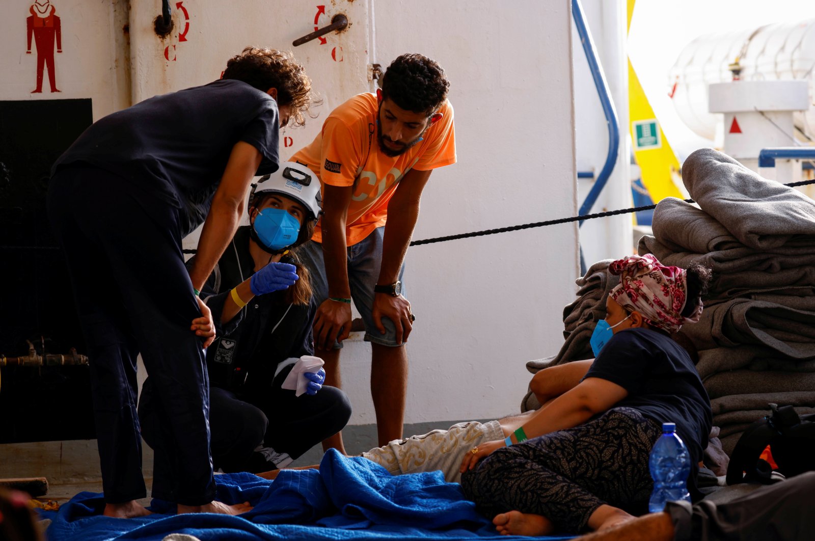 A medic talks with migrants after a migrant fell ill and collapsed on the German NGO migrant rescue ship Sea-Watch 3, while waiting for the last group of migrants to disembark from the ship in Trapani on the island of Sicily, Italy, Aug. 8, 2021. (Reuters Photo)