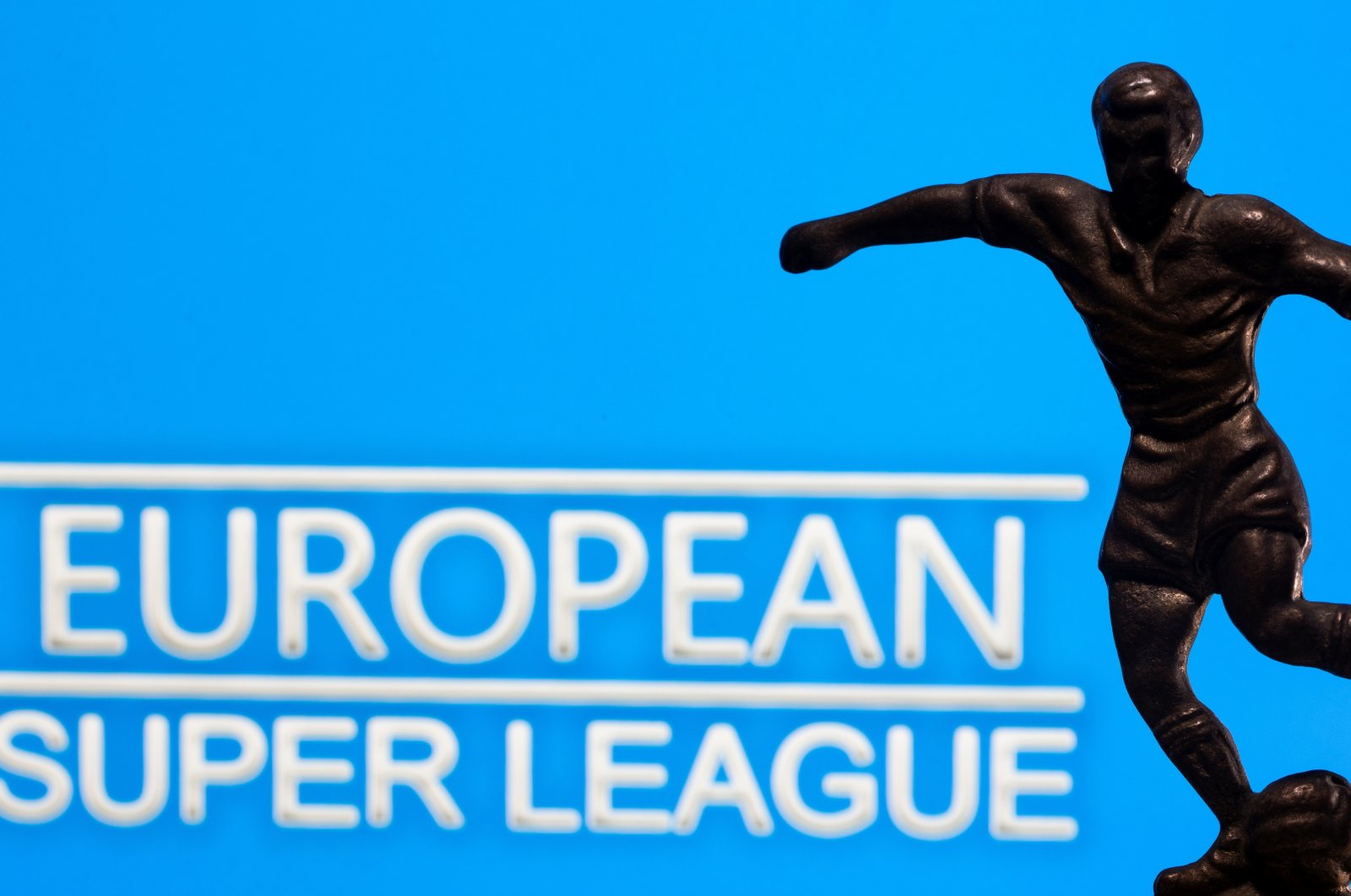 A metal figure of a football player with a ball is seen in front of the words "European Super League" in this illustration taken April 20, 2021. REUTERS/Dado Ruvic/Illustration
