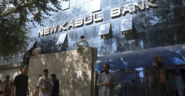 Afghans wait for hours to try to withdraw money, in front of Kabul Bank, in Kabul, Afghanistan, Aug. 15, 2021. (AP Photo)