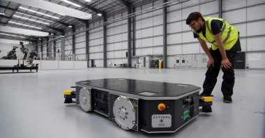 An engineer at U.K. electric van and bus maker Arrival inspects a specially developed autonomous robot at the startup's low-cost "microfactory" in Bicester, Britain, Aug. 3, 2021. (Reuters Photo)