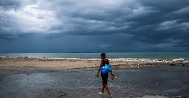 A woman wades through water as Tropical Depression Grace approaches, in Les Cayes, Haiti, Aug. 16, 2021. (Reuters Photo)