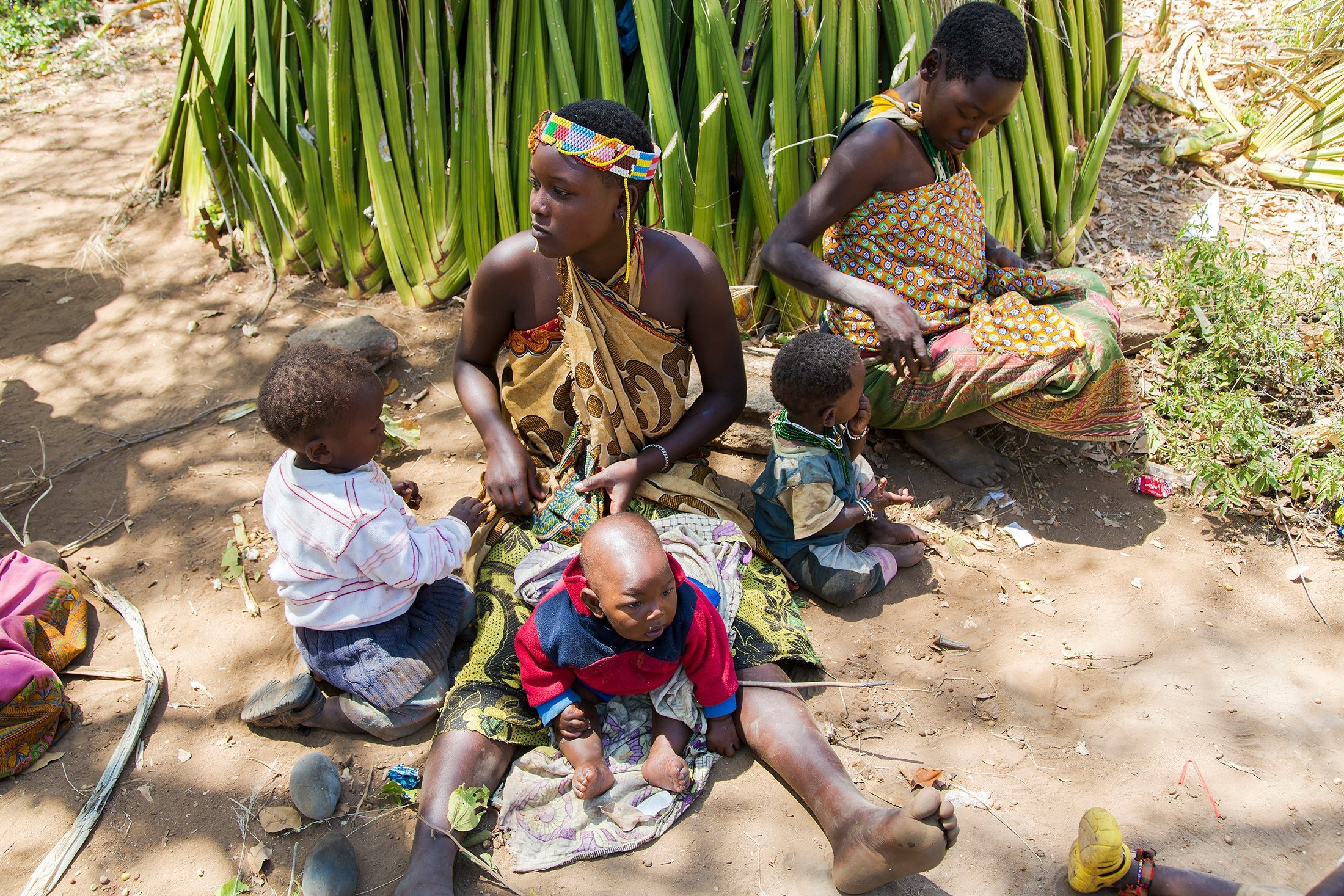 Hadza women sit with small children on the ground, in Tanzania, May 10, 2016. (Shutterstock Photo)
