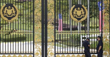 Police stand guard outside the main gate of the National Palace while Malaysia's Prime Minister Muhyiddin Yassin meets the king in Kuala Lumpur, Malaysia, Aug. 16, 2021. (AP Photo)