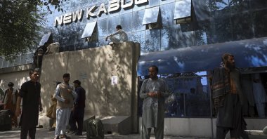 Afghans wait for hours to try to withdraw money, in front of New Kabul Bank, in Kabul, Afghanistan, Aug. 15, 2021. (AP Photo)