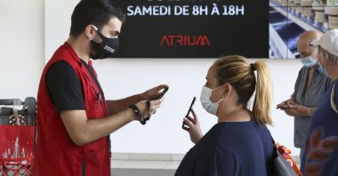 An employee of the Atrium shopping center checks a visitor's health pass in Ajaccio, South Corsica, Aug. 16, 2021. (AFP Photo)