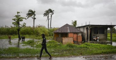 A man walks along a road in a slightly flooded area the morning after Tropical Storm Grace swept over the area in Trou Mahot, Haiti, Aug. 17, 2021. (AP Photo)