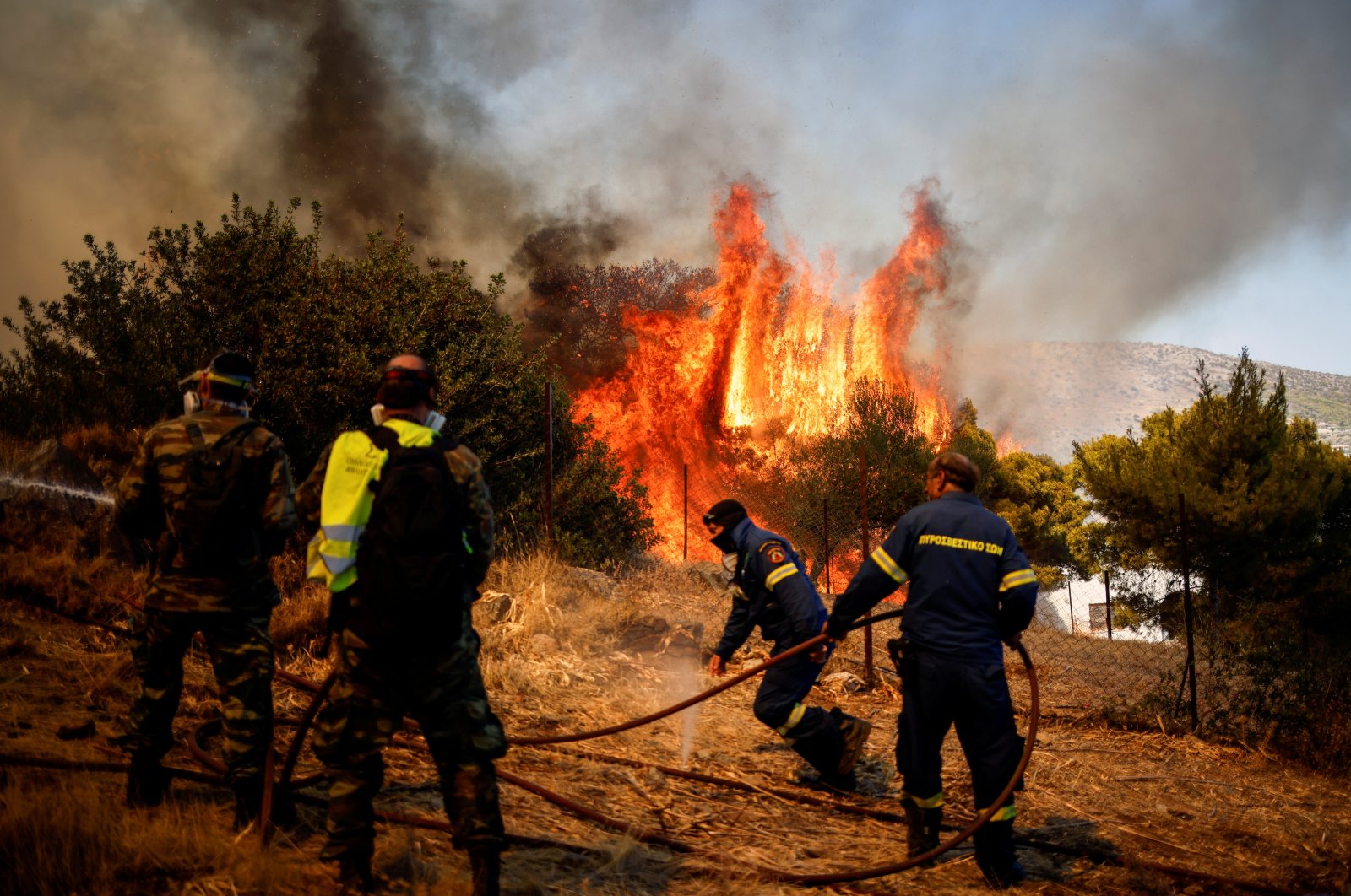 Firefighters and volunteers try to extinguish a wildfire burning in the village of Markati, near Athens, Greece, Aug. 16, 2021. (Reuters Photo)