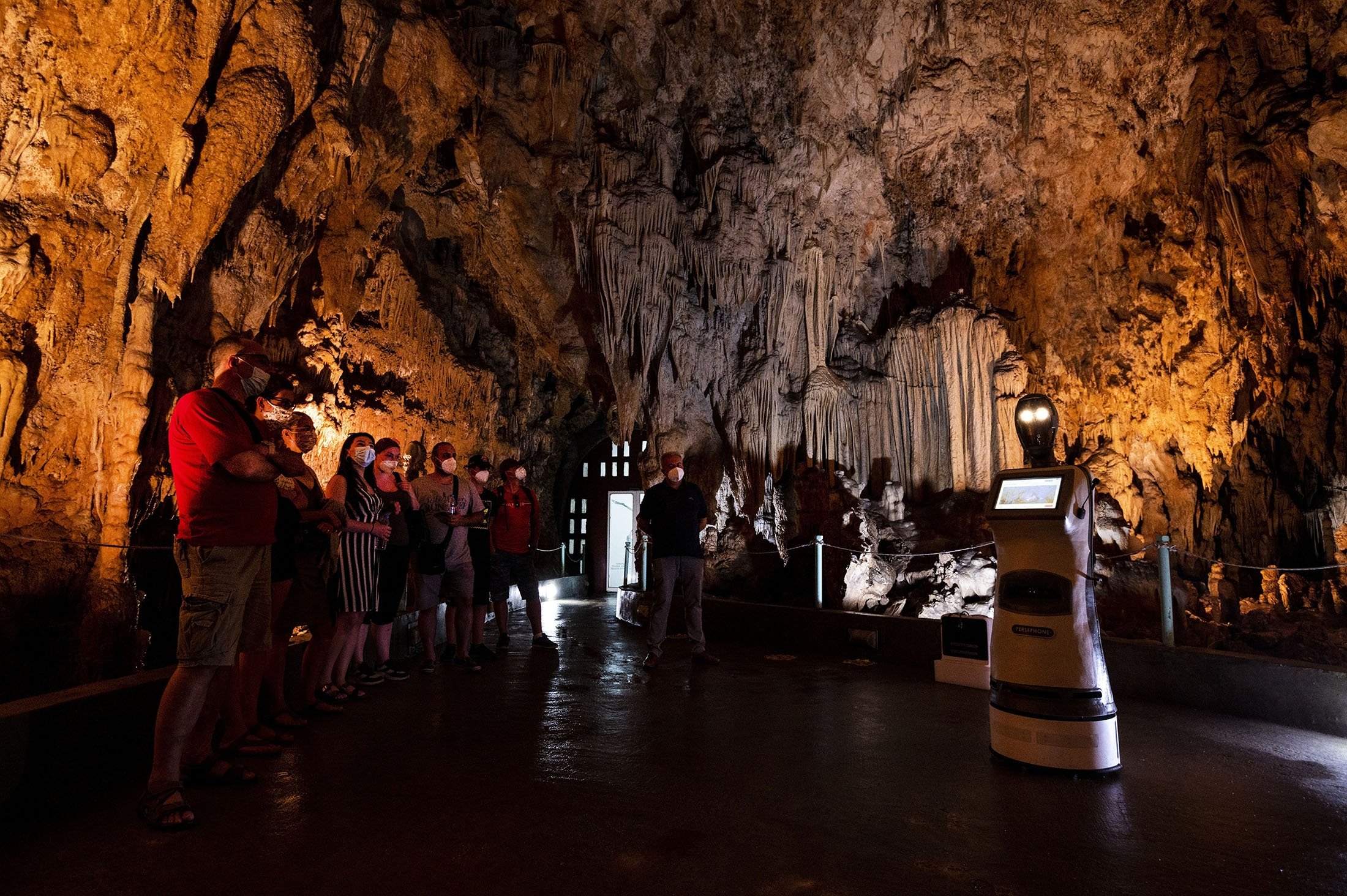 Persephone guides the visitors inside Alistrati cave, about 135 kilometers (84 miles) northeast of Thessaloniki, Greece, Aug. 2, 2021. (AP Photo)