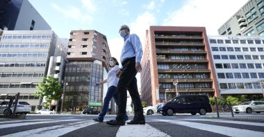 Former Nissan Motor Co. executive Greg Kelly and his wife, Dee Kelly, go for a walk in Tokyo, Japan, Aug. 18, 2021. (AP Photo)