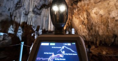 Persephone guides the visitors inside Alistrati cave, about 135 kilometers (84 miles) northeast of Thessaloniki, Greece, Aug. 2, 2021. (AP Photo)