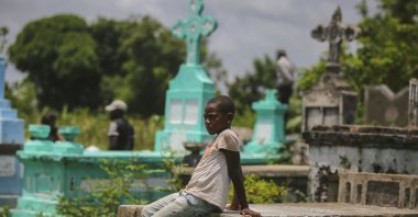 A relative attends the burial of Francois Elmay after his body was recovered from the rubble of a home destroyed by Saturday's 7.2 magnitude earthquake, in Tobek, Haiti, Aug. 18, 2021. (AP Photo/Joseph Odelyn)