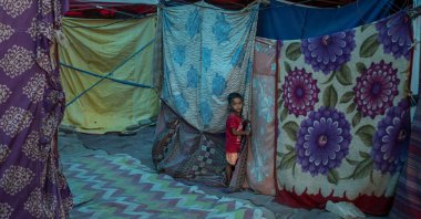 A young Rohingya refugee boy stands outside a tent at a refugee camp alongside the banks of the Yamuna River in the southeastern borders of New Delhi, India, July 1, 2021. (AP Photo)