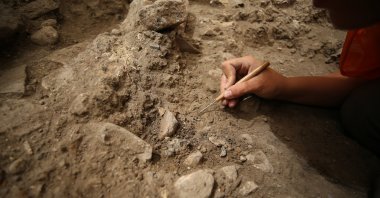 An archaeologist works in the 2,600-year-old kitchen structure in the ancient city of Daskyleion, Balıkesir, western Turkey, Aug. 17, 2021. (AA Photo)