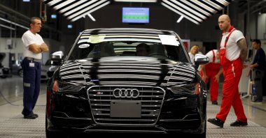 Worker stand next to a car on the assembly line as serial production of the new Audi TT roadster starts at the Audi plant in Gyor, west of Budapest, Hungary, Nov. 5, 2014. (Reuters Photo)