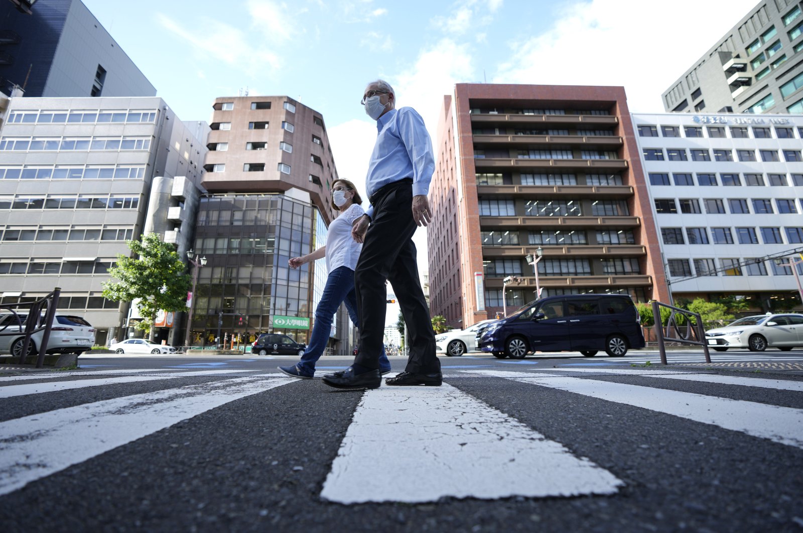 Former Nissan Motor Co. executive Greg Kelly and his wife, Dee Kelly, go for a walk in Tokyo, Japan, Aug. 18, 2021. (AP Photo)