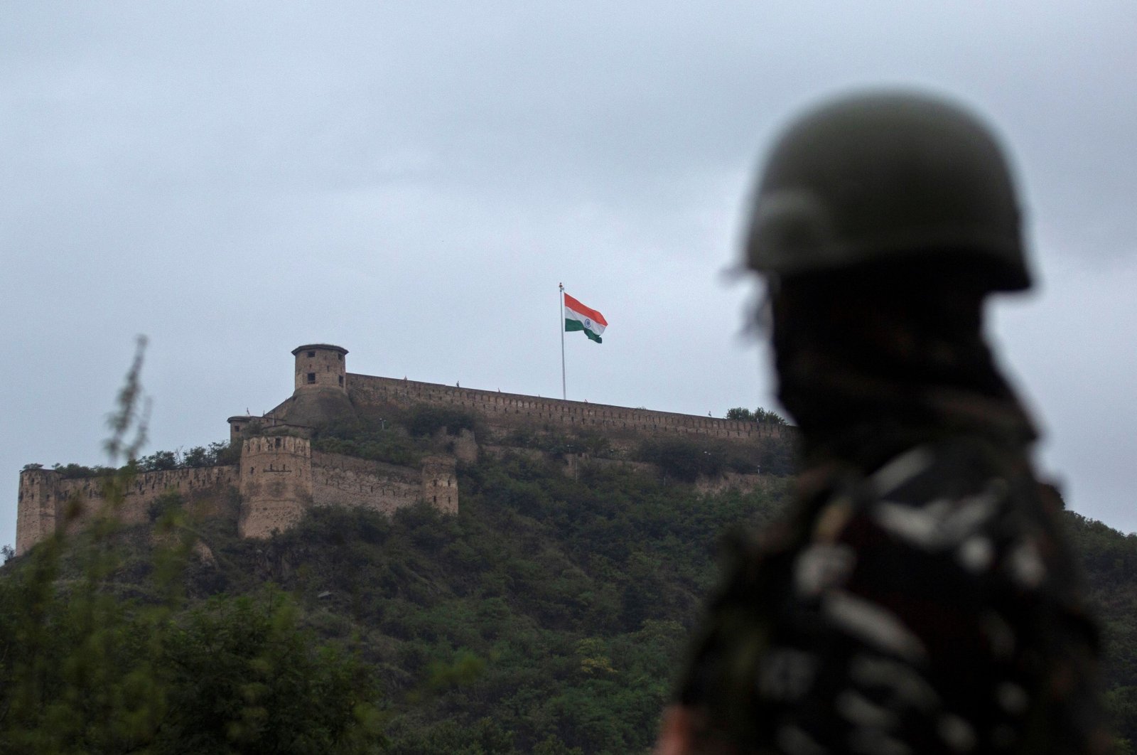 An Indian paramilitary soldier stands guard as the Indian national flag flutters on Hari Parbat Fort during the celebrations to mark India's 75th Independence Day in Srinagar, India, Aug. 15, 2021. (AFP Photo)
