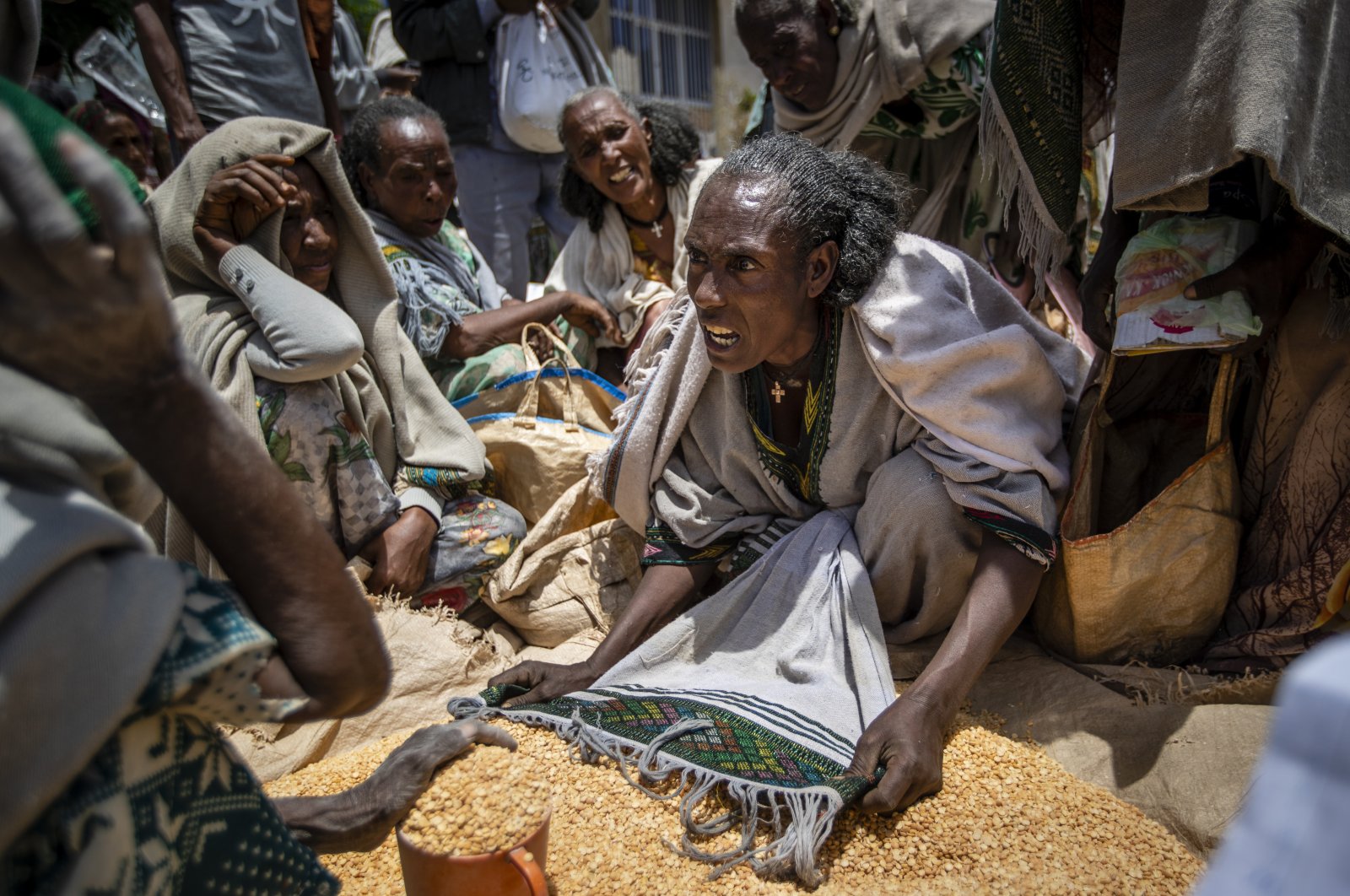 An Ethiopian woman argues with others over the allocation of yellow split peas after it was distributed by the Relief Society of Tigray in the town of Agula, in the Tigray region of northern Ethiopia, May 8, 2021. (AP Photo)
