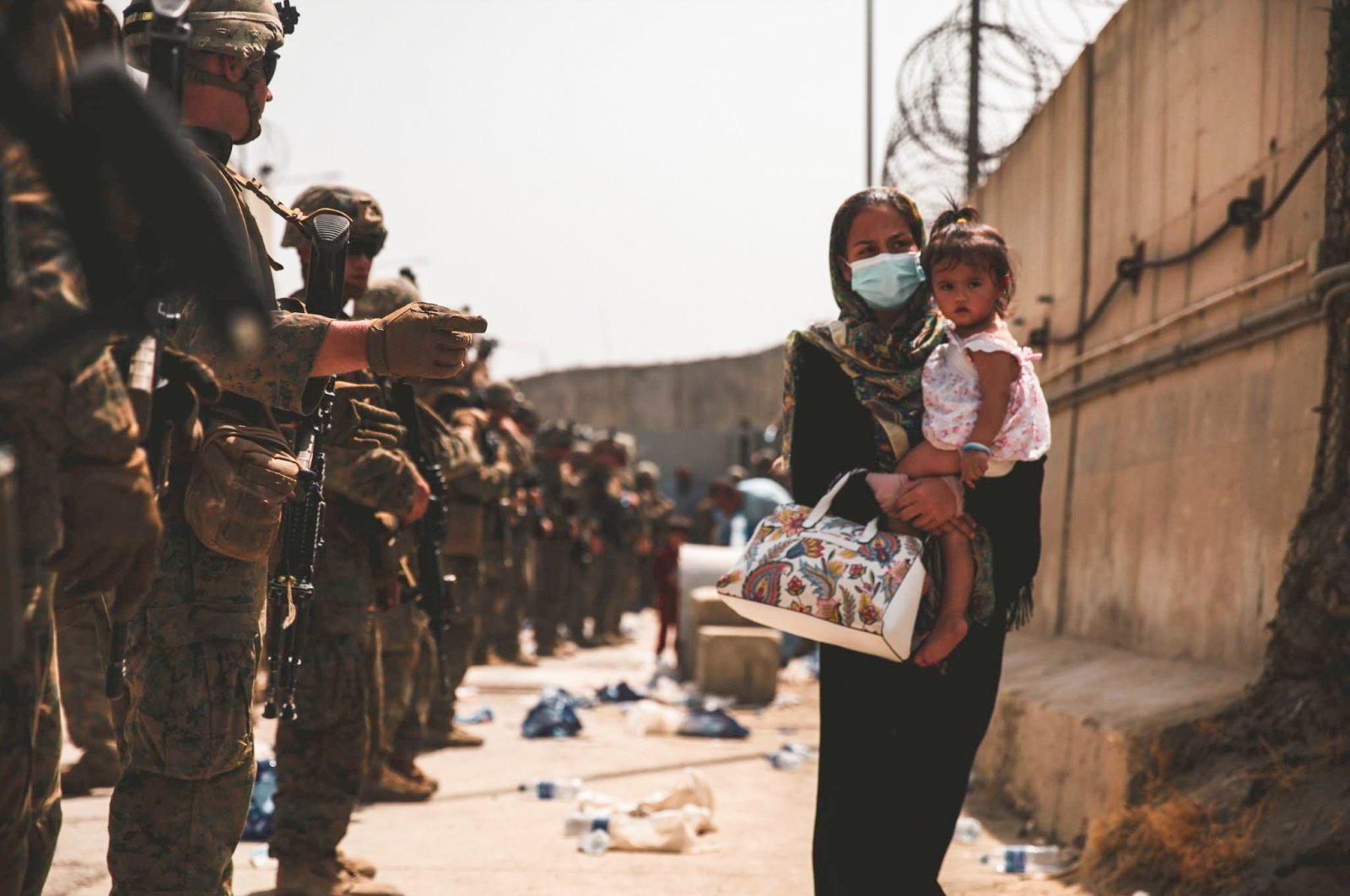 A U.S. Marine assigned to 24th Marine Expeditionary Unit guides an evacuee during an evacuation at Hamid Karzai International Airport, in Kabul, Afghanistan, Aug. 18, 2021. (Reuters Photo)