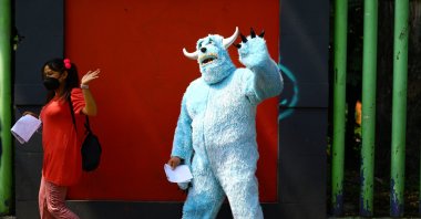 A person in a costume gestures while walking in a line to receive a dose of the Pfizer vaccine against COVID-19 during a mass vaccination for people from 18 to 29 years old, in Xochimilco, on the outskirts of Mexico City, Mexico, August 19, 2021. (Reuters Photo)